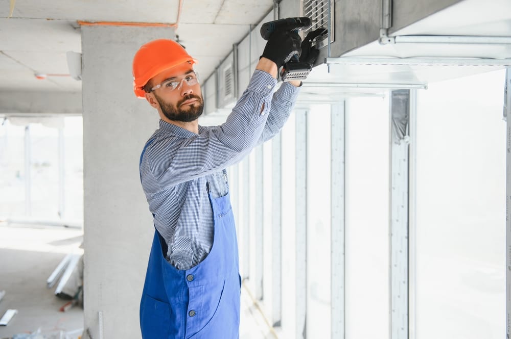 ingénieur CVC installant un système de ventilation à récupération de chaleur pour une nouvelle maison.